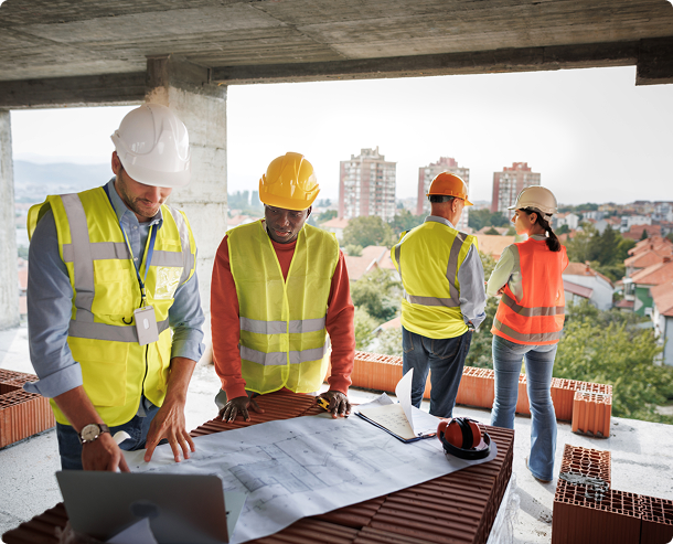 Colleagues analyzing project on construction site