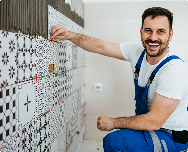 Handyman applying tiles with adhesive
